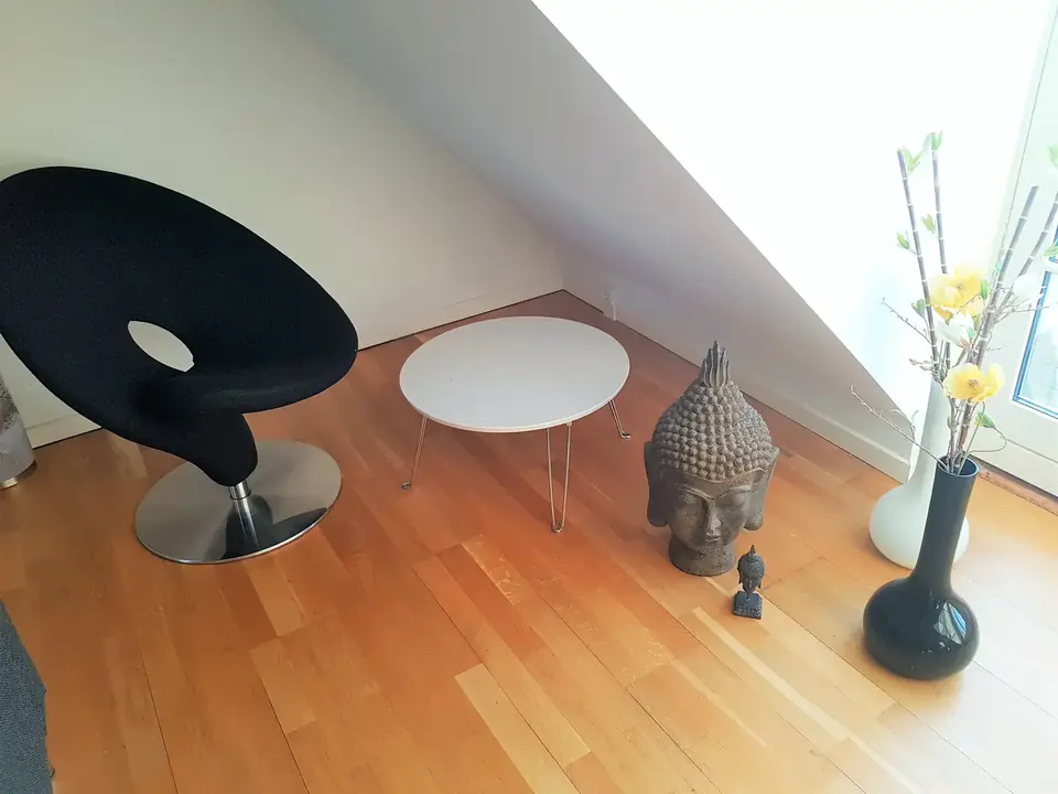 Lænestole og rundt bord under skråvæggen